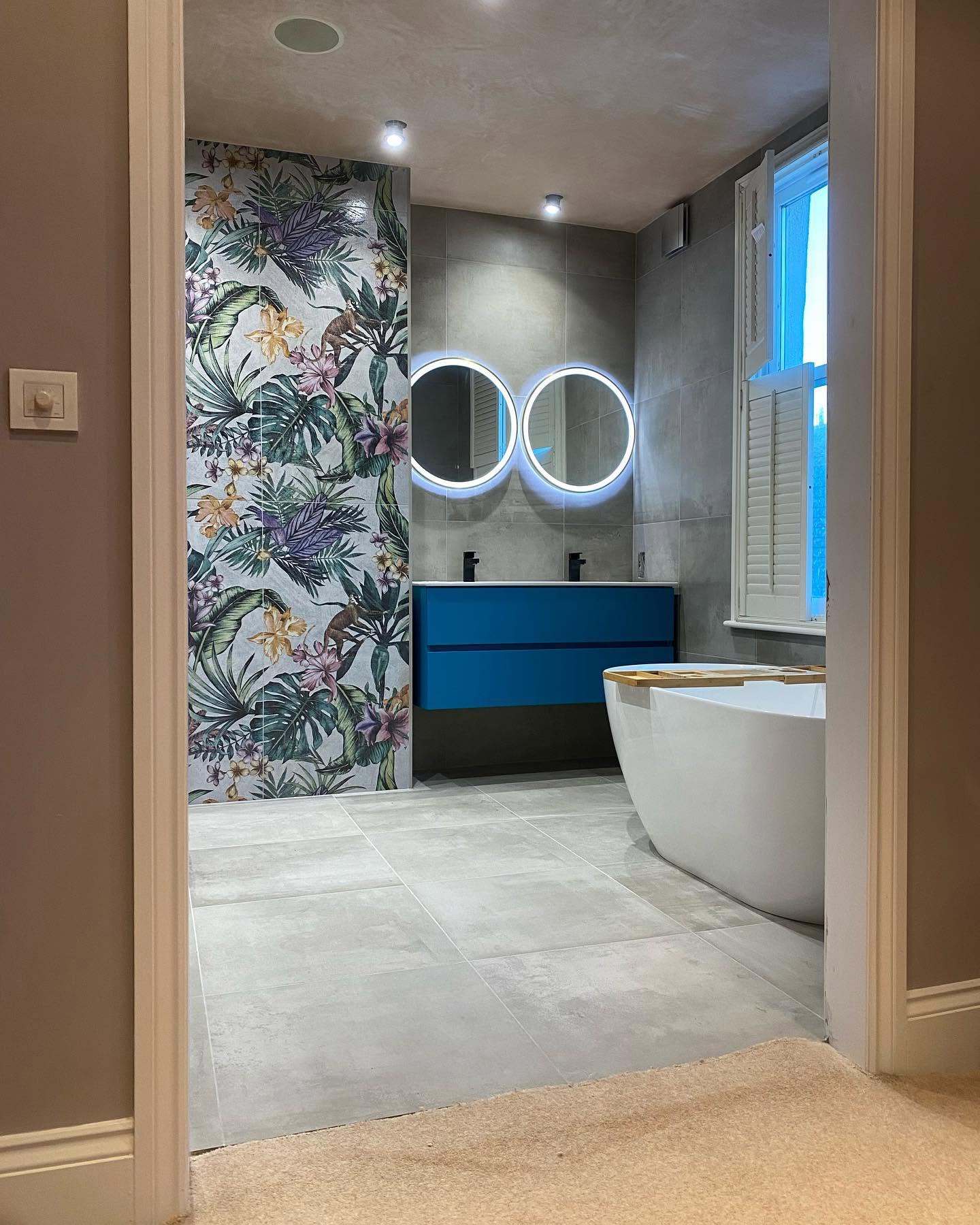 Contemporary bathroom with tropical mural, twin illuminated mirrors and blue vanity