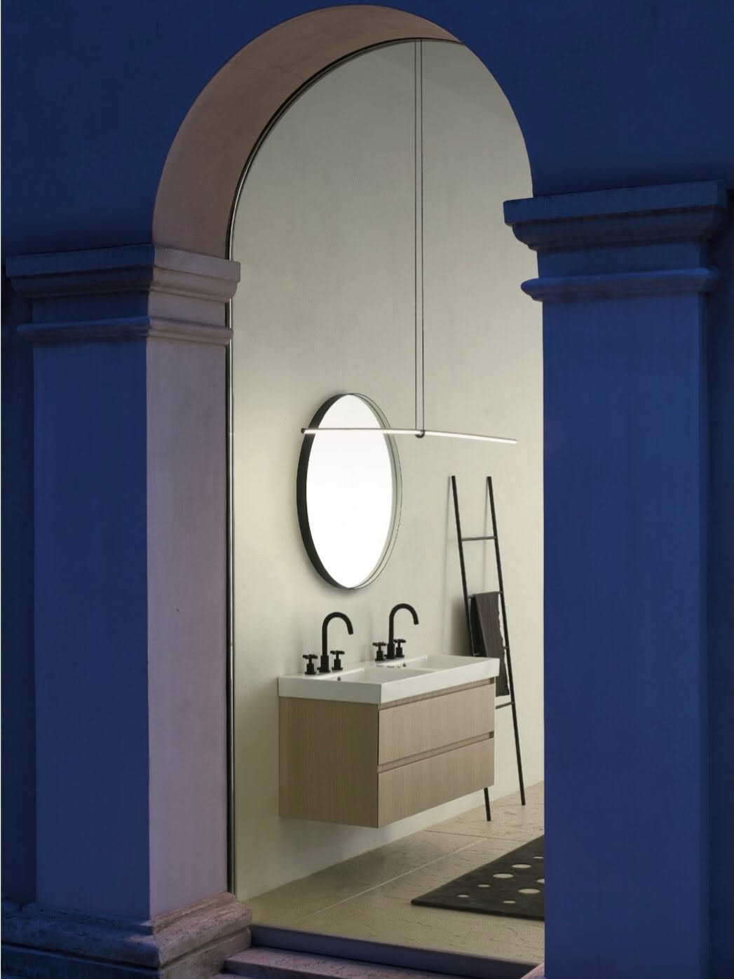 Minimal vanity framed by a grand illuminated arch